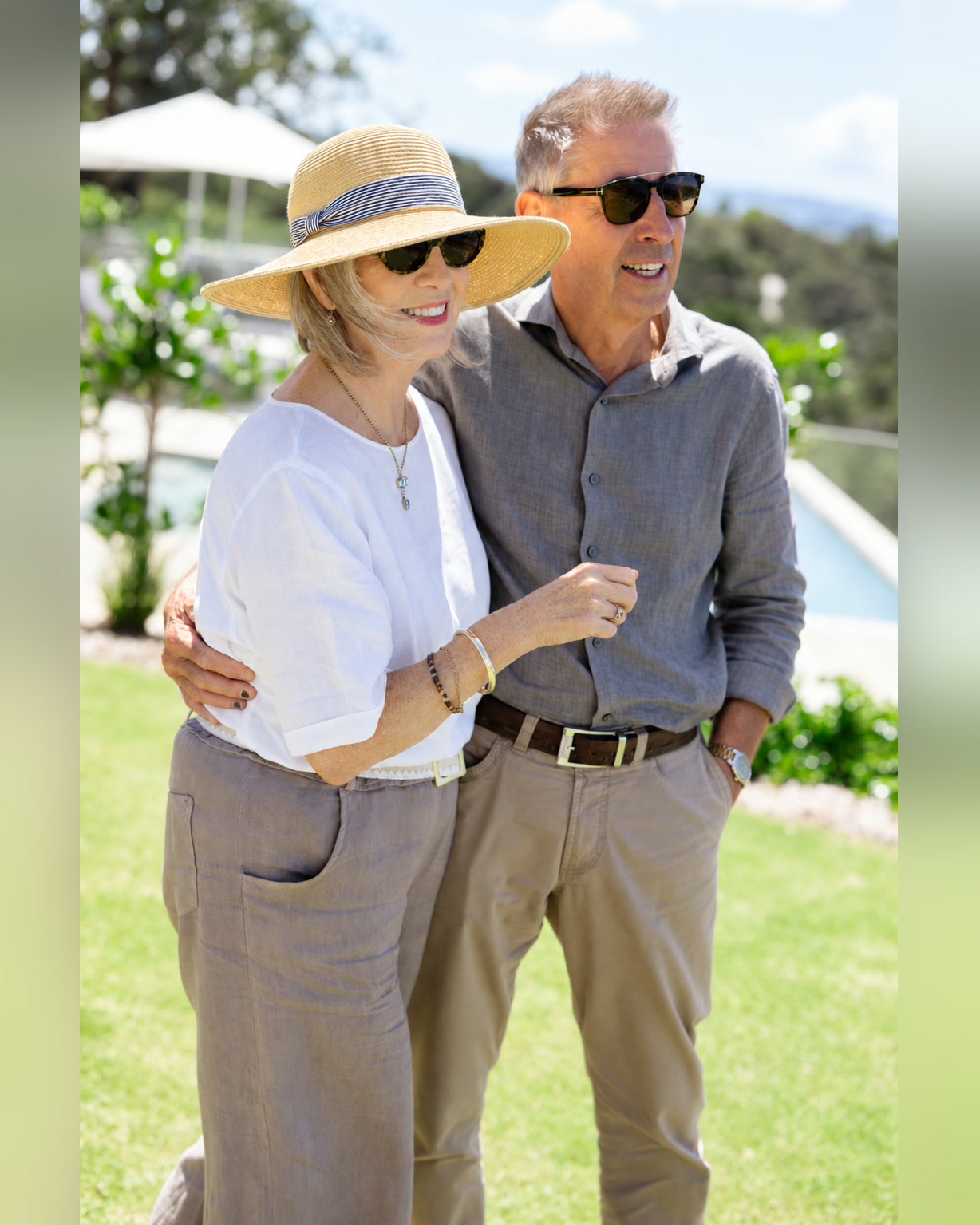 Andrew Szczepanski, property manager at Bluestone Estate, with his wife Jill on the lawn at Bluestone Ridge, both in sunglasses and smiling, the pool and umbrellas behind.