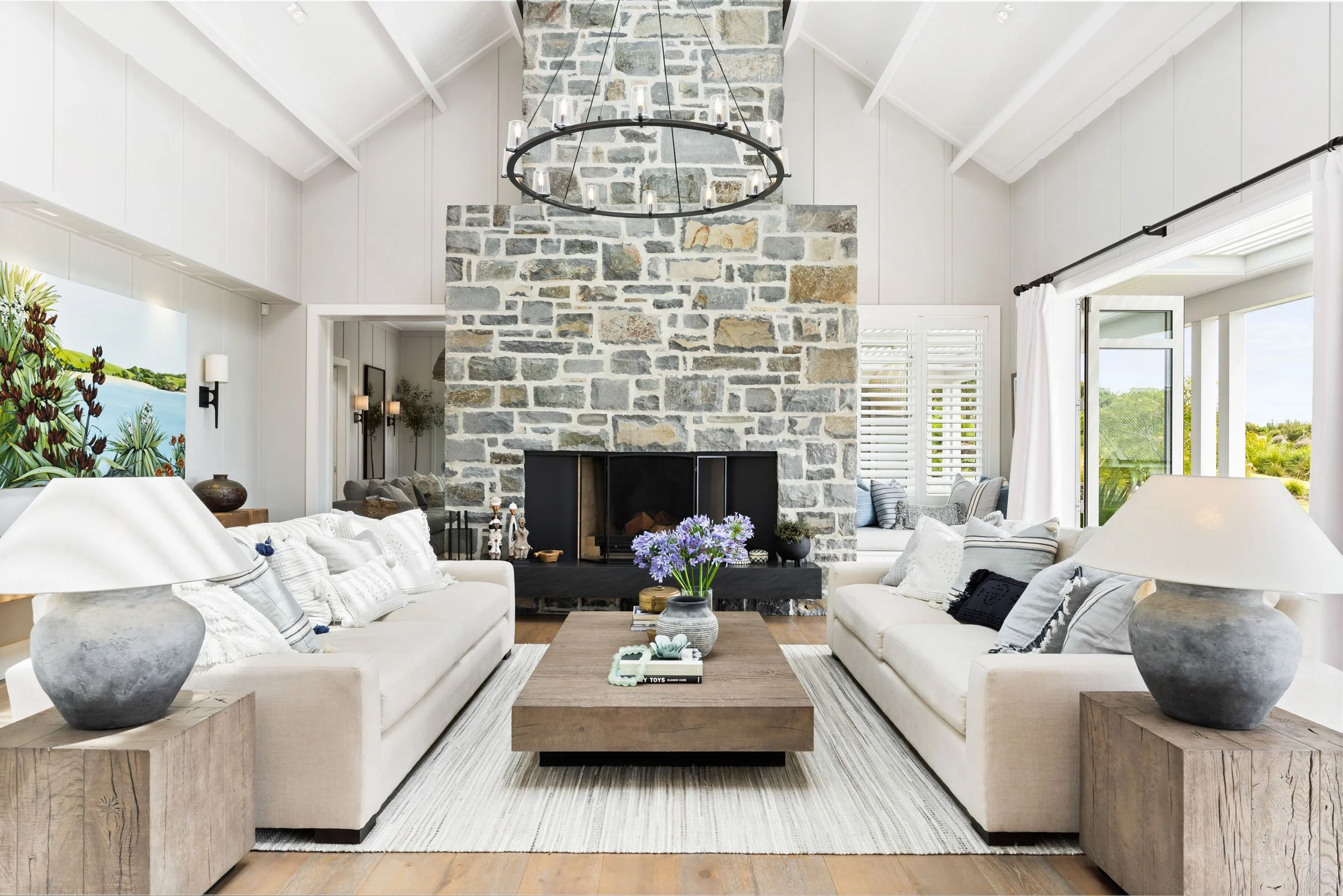 The Main House living room at Bluestone Estate, with the floor-to-ceiling South Island bluestone fireplace.