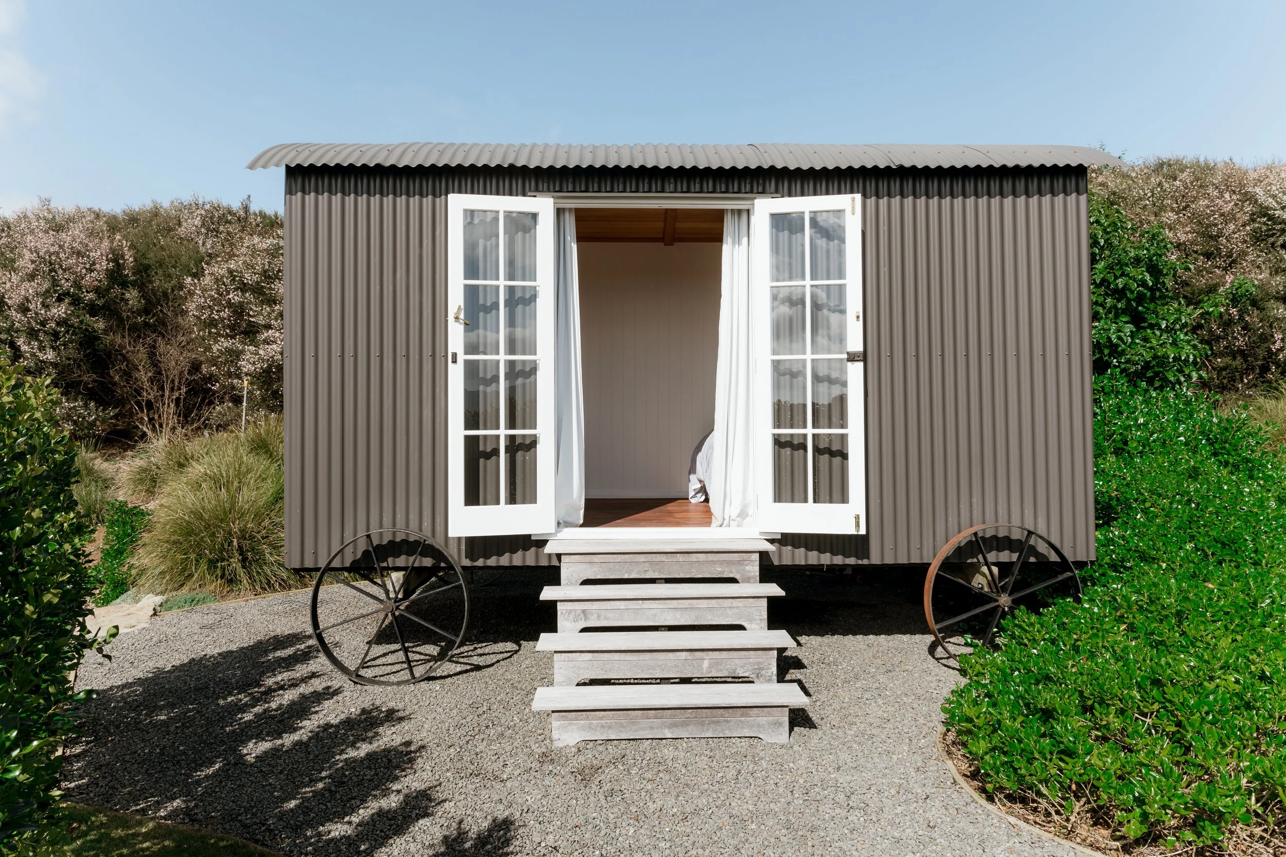 The Shepherd's Hut, the Boat House's second bedroom at Bluestone Estate, with its French doors open.